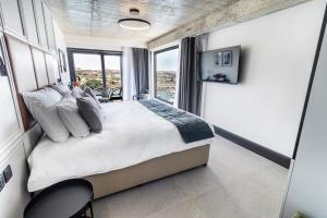 a bedroom with a large bed with a large window at The Londoner Hotel Sliema in Sliema