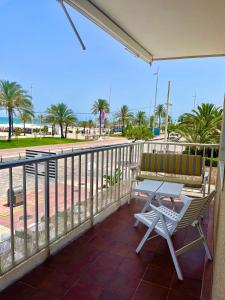 een balkon met een tafel en een stoel en uitzicht op het strand bij Apartamento TalaMar Gandia Playa in Playa de Gandia