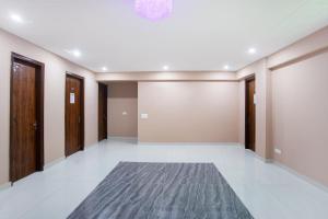 una habitación vacía con un pasillo con puertas y una alfombra en Super Capital O 62990 Harish Residency, en Gurgaon