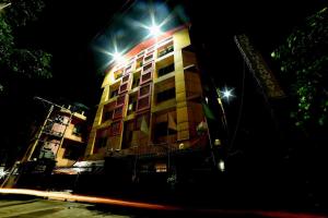 un edificio con luces por la noche en Collection O Hotel Highway Palace, en Dispur