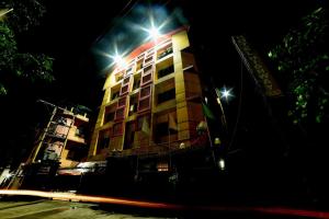 un edificio con luces por la noche en Collection O Hotel Highway Palace, en Dispur