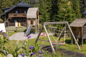 a playground in front of a log cabin at Hapimag Ferienwohnungen Sonnleitn in Sonnenalpe Nassfeld