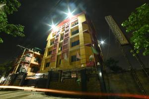 un edificio con luces por la noche en Collection O Hotel Highway Palace, en Dispur