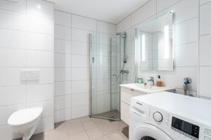 a white bathroom with a sink and a washing machine at Brand new in Bergen