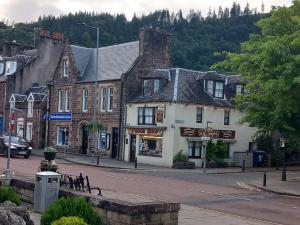 a street in a small town with buildings at Stunning Village Centre Holiday Home in Callander