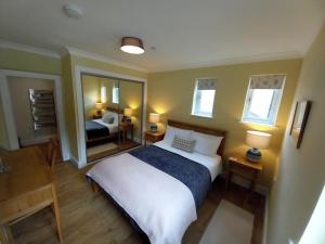 a bedroom with a large bed and a mirror at Stunning Village Centre Holiday Home in Callander