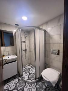 y baño con ducha y lavamanos. en Hotel Otağ, en Estambul