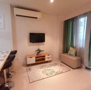 Maribago的住宿－TAMBULI SEASIDE LIVING STAYCATION，客厅的墙上配有平面电视。