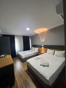 pokój hotelowy z 2 łóżkami i lampą w obiekcie Hotel Otağ w Stambule