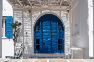 une porte bleue sur le côté du bâtiment dans l'établissement Livadia Seaside Studios 7, à Parikia