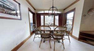 une salle à manger avec une table, des chaises et un lustre dans l'établissement Vail Village Plaza Lodge 3 Bedroom Condo, à Vail