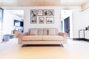 a white living room with a couch and pictures on the wall at The Londoner Hotel Sliema in Sliema