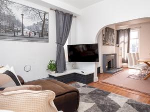 sala de estar con TV de pantalla plana y chimenea en Pass the Keys Spacious home near City Centre en Mánchester