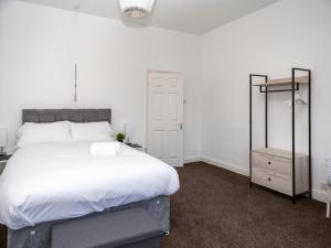 1 dormitorio con 1 cama blanca grande y espejo en Pass the Keys Spacious home near City Centre en Mánchester