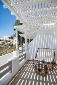 a white pergola on a white patio with a wooden box at Super Paradise Hotel in Super Paradise Beach