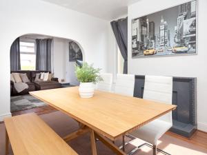 a dining room with a wooden table and white chairs at Pass the Keys Spacious home near City Centre in Manchester