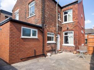 a brick house with a table in front of it at Pass the Keys Spacious home near City Centre in Manchester