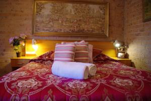 een bed met twee kussens en twee handdoeken erop bij White Lanterns Motel in Armidale