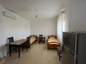 a room with a table and chairs and a refrigerator at Laert's Home in Sarandë