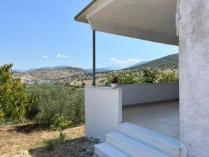 a house with a balcony with mountains in the background at Laert's Home in Sarandë