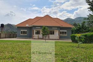 ein Haus mit einem roten Dach und einem grünen Hof in der Unterkunft BLT Residence - Kasese A serene and tranquil home in Kasese