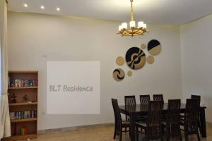 ein Esszimmer mit einem schwarzen Tisch und Stühlen in der Unterkunft BLT Residence - Kasese A serene and tranquil home in Kasese