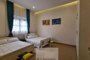 1 Schlafzimmer mit 2 Betten und einem Fenster in der Unterkunft BLT Residence - Kasese A serene and tranquil home in Kasese