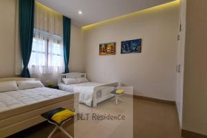 卡塞斯BLT Residence - Kasese A serene and tranquil home的有两张床和一扇窗户的卧室