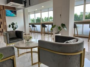 ein Wohnzimmer mit 2 Stühlen und einem Tisch in der Unterkunft Golden Nest Hotel Suvarnabhumi in Bangkok