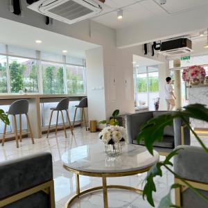un soggiorno con tavolo e sedie di Golden Nest Hotel Suvarnabhumi a Bangkok