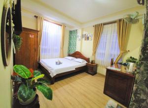 a hotel room with a bed and a plant at Bình Đào Hotel - Khách sạn ngay trung tâm giá rẻ in Da Lat