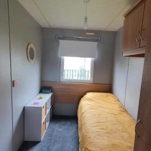 מיטה או מיטות בחדר ב-Pet friendly family caravan with secure private garden