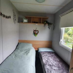um pequeno quarto com duas camas num reboque em Pet friendly family caravan with secure private garden em Patrington