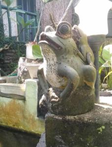 una estatua de una rana sentada en una roca en Villa Bamboo Bujak Permai, en Praya