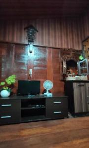 Habitación con escritorio, ventilador y espejo. en Villa Bamboo Bujak Permai, en Praya