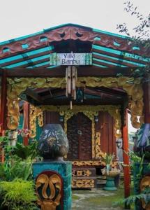 un pequeño edificio con una estatua delante de él en Villa Bamboo Bujak Permai, en Praya