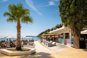 einen Strand mit Palmen und Stühlen in der Unterkunft Luxury Apartments Mazza - Veronica in Dubrovnik