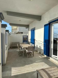 a patio with a table and chairs on a balcony at Onda Azzurra in Milazzo +6 photos