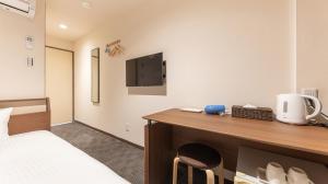 een hotelkamer met een bed en een bureau bij FLY CAT HOTEL in Minokamo