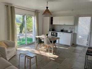 a kitchen and living room with a table and chairs at La Bastide de Lolig - CLIM - WiFi in Sarrians