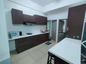 a kitchen with brown cabinets and a white floor at Golden Hills Pasar Malam 3 Bedroom Apartment J LouvRe in Tanah Rata