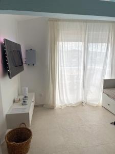 a white room with a large window and a television at Riva House Tribunj in Tribunj