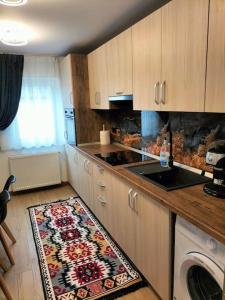cocina con fogones y alfombra en el suelo en Apartament Ary, en Borşa