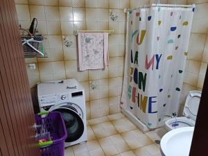 a washing machine in a bathroom with a shower curtain at MATAS HOUSE in Leonidion