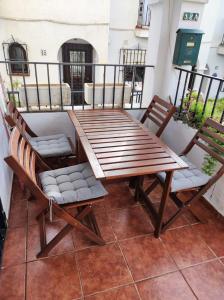 a wooden table and chairs on a balcony at HACIENDA 12A MENYBER in Nerja