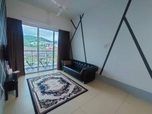 a living room with a couch and a large window at Golden Hills Pasar Malam 3 Bedroom Apartment J LouvRe in Tanah Rata