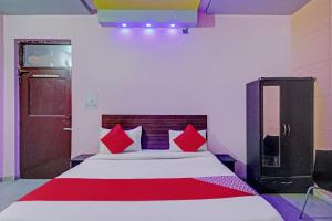1 dormitorio con 1 cama con almohadas rojas y puerta en OYO Rj Villa en Indirapuram