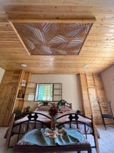 a bedroom with a bed and a wooden ceiling at Oak Farm مزرعة الملّول in Ajloun