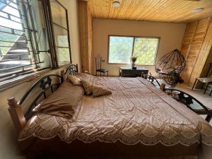 a bedroom with a bed in a room with windows at Oak Farm مزرعة الملّول in Ajloun