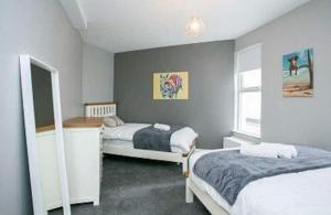 a bedroom with two beds and a window at AMAZING 3 BEDROOM HOME, PRIME BT1 POSTCODE AND CITY CENTRE LOCATION in Belfast